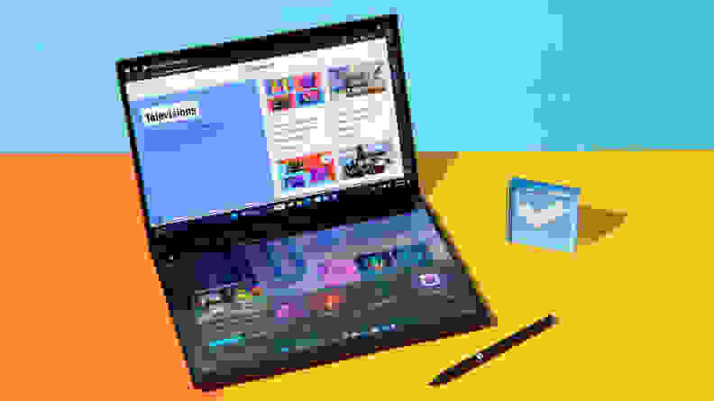 Stylus pen sitting next to 2024 Asus Zenbook Duo laptop on top of orange and yellow split desk.