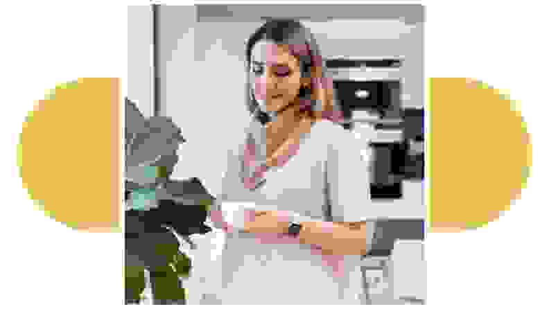 A person wearing a Drybble bib around their neck while scrolling on a smartphone.