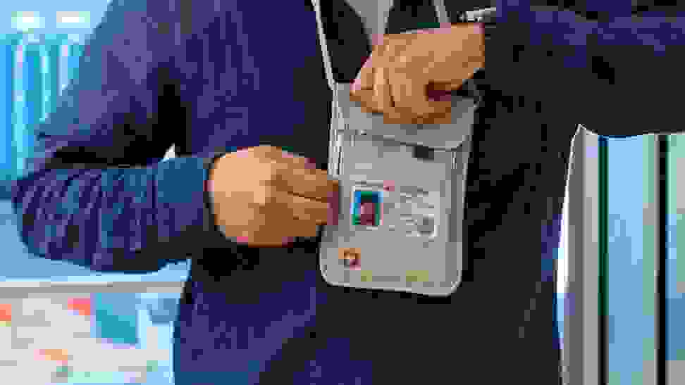 A person getting cash out of their travel wallet at the airport.