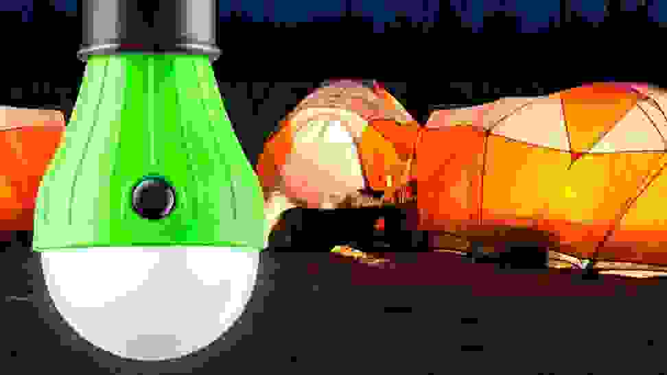 A camping lantern being used by a family at a campsite.