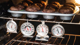 Four of the best oven thermometers Reviewed tested hang inside an oven under a tray of chocolate muffins.