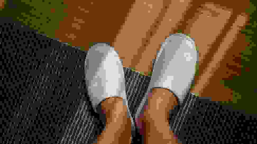 Man wearing a pair of white slippers.