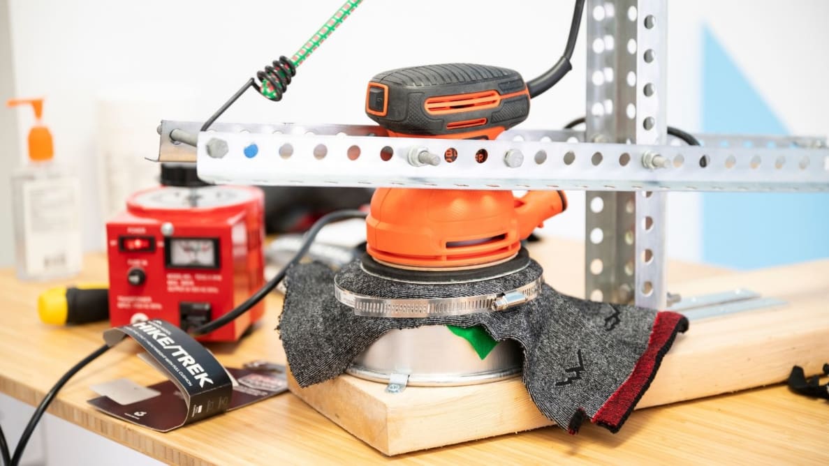A pair of Darn Tough Vermont hiking socks clamped down and subjected to 180-grit sandpaper via an orbital sander.