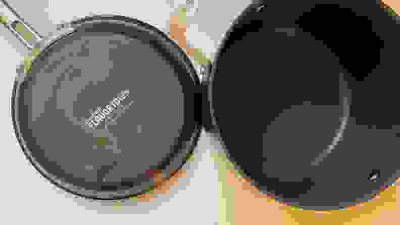 A discolored, worn bottom of the Guy Fieri Flavortown Laser Titanium skillet and the empty inside of a pot.