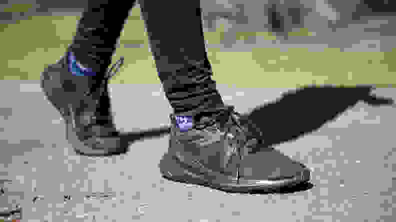 A close-up of the black Lululemon sneakers while walking on a sidewalk