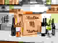 A Misfits Market open box sitting on a marble countertop surrounded by  wine bottles