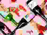 Assorted bottle of colorful wine arranged on a light pink surface.