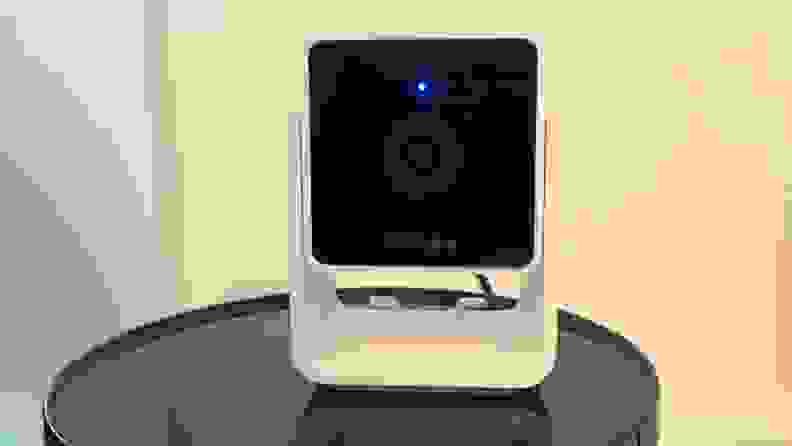 The Petcube Cam sits on a black surface.