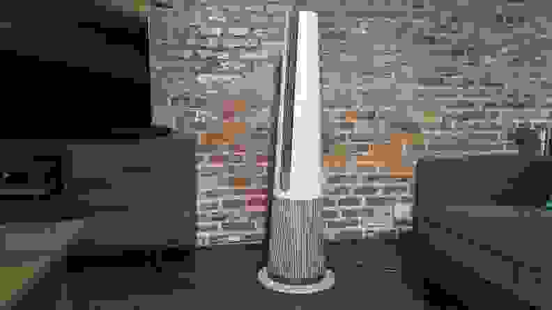 The LG PuriCare AeroTower sitting in a room against a brick wall