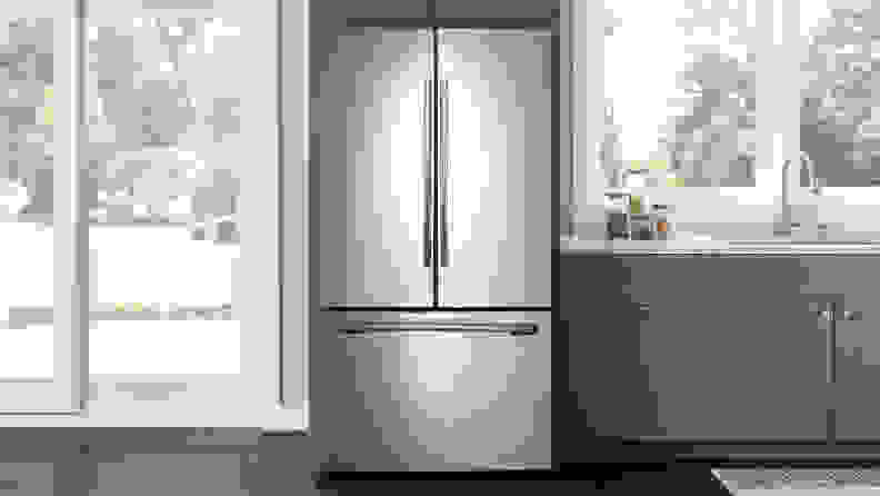 The Samsung RF260BEAESR French-door refrigerator, installed in a modern kitchen that's full of windows letting light in from the backyard.