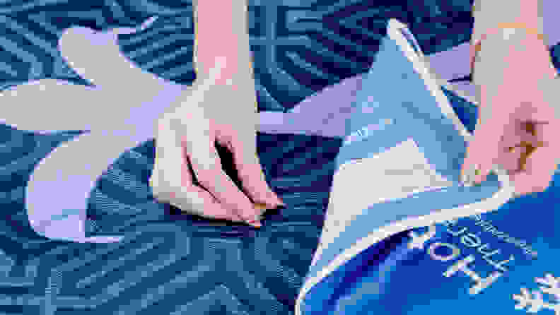 A person placing heat sensors on a mattress.