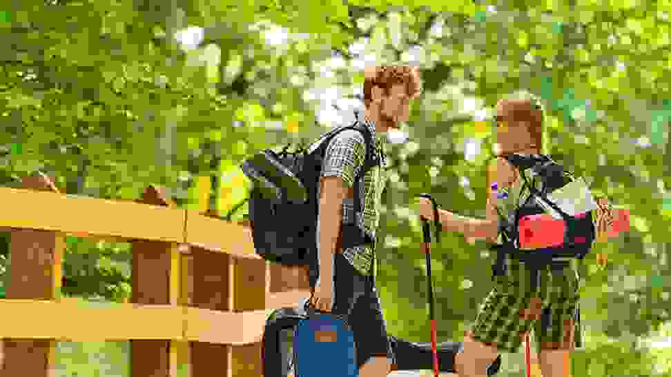 A pair of campers make their way through nature with the Wealers 11-piece camping utensil set in their pack.