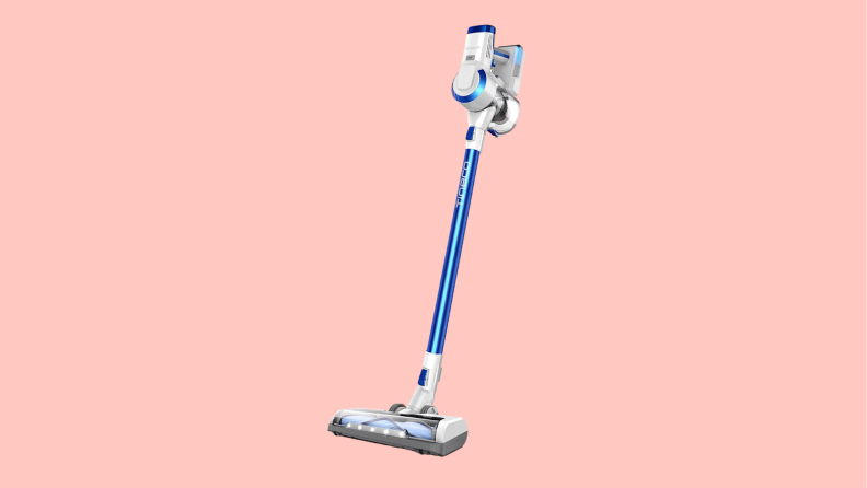The Tineco vacuum sits on a pink background, it features a blue neck and a futuristic looking handle.