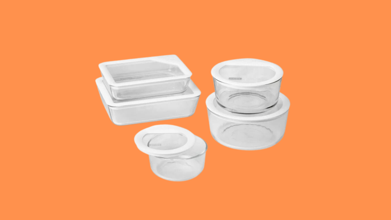 Five Pyrex containers of various shapes and sizes sit on an orange background.