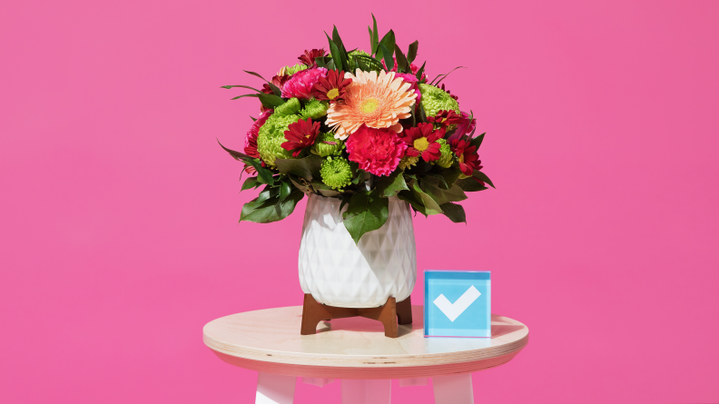 A bouquet of pink and green flowers against a pink background.